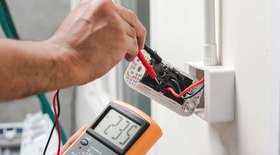 Electrician performing electrical updates checking voltage with a digital meter