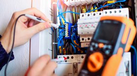 Image of fixing wires using a multimeter; Questions to ask an electrician include their specialties.